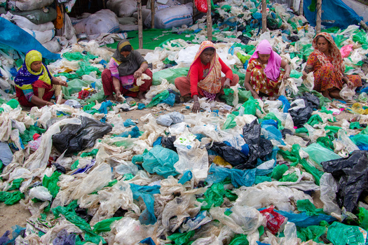 Keraniganj Bangladesh 05 February 2023 View of women sitting on the ground and sorting through large piles of plastic waste for recycling in an outdoor facility. Keraniganj Bangladesh 05 February 2023 View of women sitting on the ground and sorting through large piles of plastic waste for recycling in an outdoor facility.