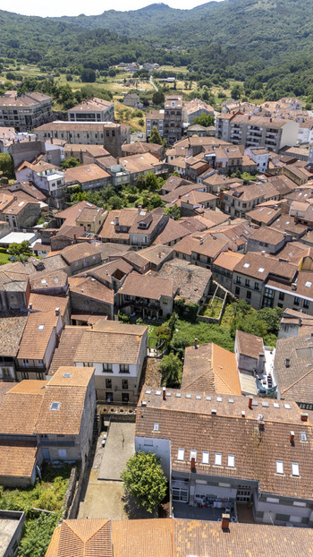 Aerial view of the historic town of Allariz featuring dense terracotta rooftops stone architecture and surrounding green hills in Allariz Province of Ourense Spain. Aerial view of the historic town of Allariz featuring dense terracotta rooftops stone architecture and surrounding green hills in Allariz Province of Ourense Spain.