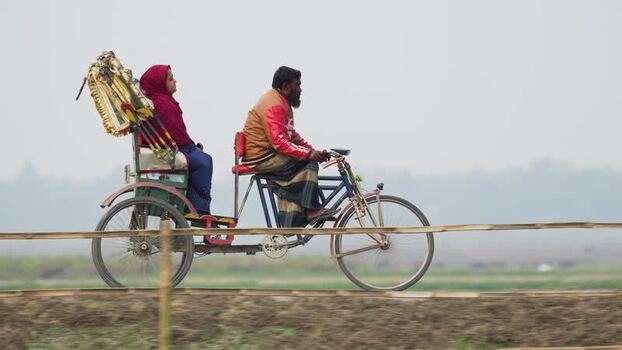 View of a man pedaling a cycle rickshaw in Bogura Bangladesh.