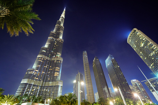 Dubai United Arab Emirates 19 April 2023 View of Burj Khalifa illuminated at night with surrounding skyscrapers and palm trees in the city center. Dubai United Arab Emirates 19 April 2023 View of Burj Khalifa illuminated at night with surrounding skyscrapers and palm trees in the city center.