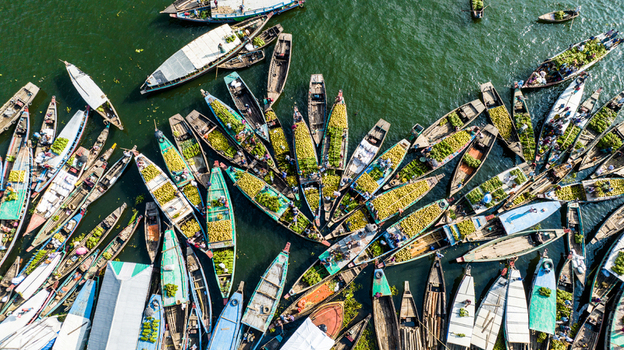 Rangamati Bangladesh 19 October 2022 Aerial view of numerous wooden boats laden with produce docked at the Rangamati floating market with calm water and vibrant activity.