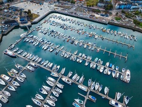 Aerial view of Bangor Harbour and Town with numerous yachts and boats docked in the marina surrounded by urban buildings and coastal infrastructure in Bangor Northern Ireland United Kingdom.