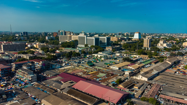 Accra Ghana 26 May 2023 Aerial view of the city center featuring modern office buildings traditional market stalls with red roofs and busy transport hubs. Accra Ghana 26 May 2023 Aerial view of the city center featuring modern office buildings traditional market stalls with red roofs and busy transport hubs.