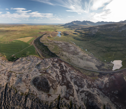 Aerial view of Ytri Raudarmelskula volcanic crater surrounded by lava fields winding roads and green pastures in Raudhamelur Eyja og Miklaholtshreppur Iceland. Aerial view of Ytri Raudarmelskula volcanic crater surrounded by lava fields winding roads and green pastures in Raudhamelur Eyja og Miklaholtshreppur Iceland.