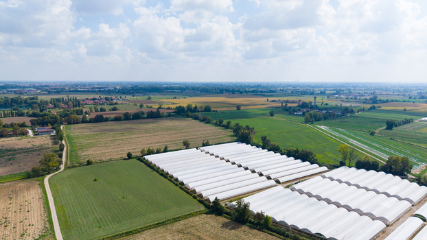 Aerial view of greenhouses for growing vegetables such as cucumbers tomatoes eggplants and peppers set within the agricultural landscape of San Giuliano Milanese Lombardy Italy. Aerial view of greenhouses for growing vegetables such as cucumbers tomatoes eggplants and peppers set within the agricultural landscape of San Giuliano Milanese Lombardy Italy.