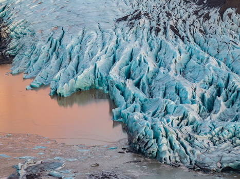 Aerial view of Svinafellsjokull glacier with deep blue crevasses and meltwater lagoon Sveitarfelagid Hornafjordur Iceland. Aerial view of Svinafellsjokull glacier with deep blue crevasses and meltwater lagoon Sveitarfelagid Hornafjordur Iceland.