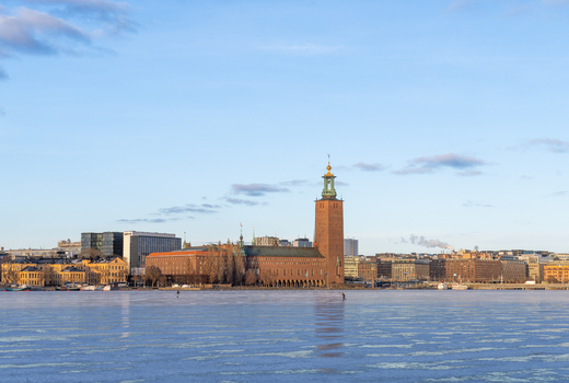 Stockholm Sweden 16 February 2026 View of Stockholm City Hall across the frozen Riddarfjarden water with its iconic brick tower under a clear winter sky.