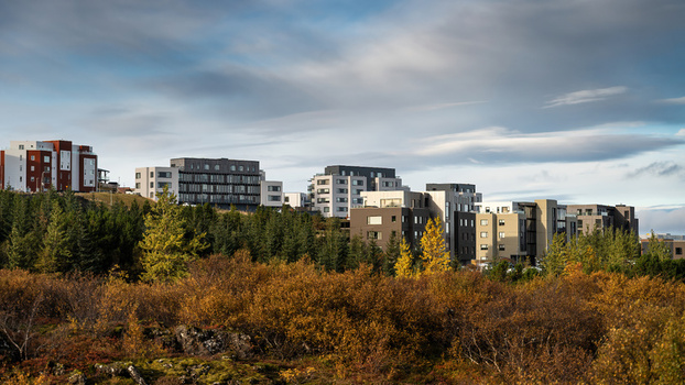 View of a modern residential complex nestled among autumn colored trees and shrubs in Iceland.