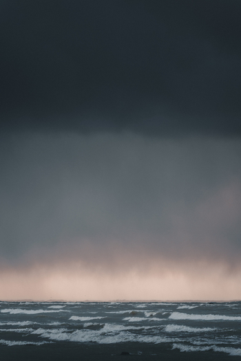 View of the stormy sea at Vormsi with dark clouds and waves crashing under a dramatic sky in Laane County Estonia.