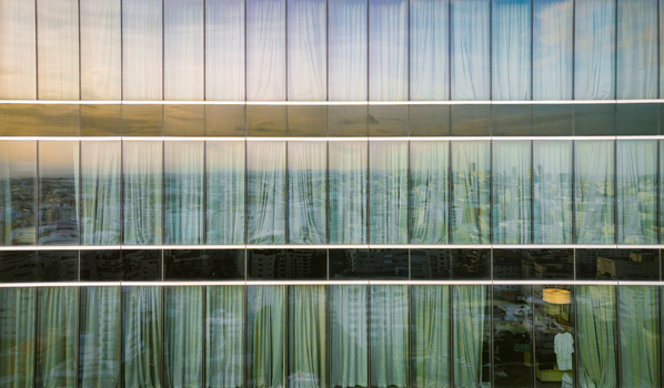 Aerial view of the modern glass facade of a high rise building reflecting the surrounding urban skyline and city streets in Santo Domingo Distrito Nacional Dominican Republic. Aerial view of the modern glass facade of a high rise building reflecting the surrounding urban skyline and city streets in Santo Domingo Distrito Nacional Dominican Republic.