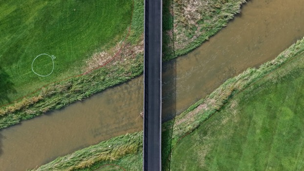Aerial view of the bridge crossing Cherry Creek surrounded by lush green grass and natural vegetation in Denver Colorado United States. Aerial view of the bridge crossing Cherry Creek surrounded by lush green grass and natural vegetation in Denver Colorado United States.