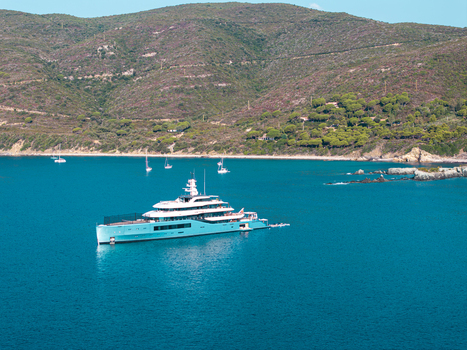 Aerial view of the luxury yacht Netto II anchored in the turquoise waters of Lacona Bay on the island of Elba surrounded by lush green hills Lacona Tuscany Italy.