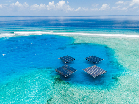 Aerial view of SolarSea floating solar power plant by Swimsol in a turquoise lagoon with coral reefs and deep blue ocean in Dharavandhoo Baa Atoll Maldives. Aerial view of SolarSea floating solar power plant by Swimsol in a turquoise lagoon with coral reefs and deep blue ocean in Dharavandhoo Baa Atoll Maldives.