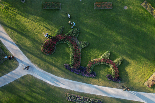 Aerial view of colorful flower beds in abstract shapes with people walking on paths in a green park in Morges Vaud Switzerland. Aerial view of colorful flower beds in abstract shapes with people walking on paths in a green park in Morges Vaud Switzerland.