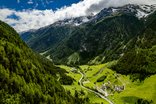 Aerial view of the lush green Kaunertal valley with the village of Prutz nestled among dense pine forests winding roads and snow capped peaks in the background Prutz Tyrol Austria. Aerial view of the lush green Kaunertal valley with the village of Prutz nestled among dense pine forests winding roads and snow capped peaks in the background Prutz Tyrol Austria.