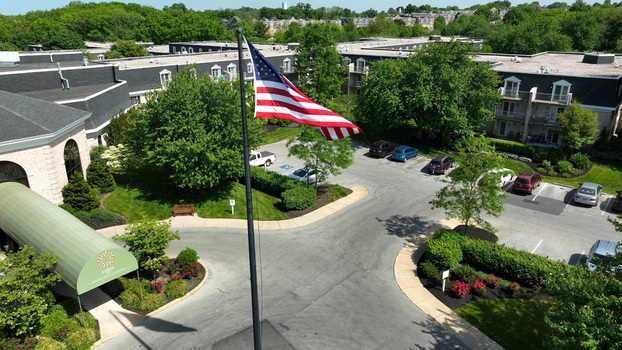 Aerial view of the retirement community campus in West Lampeter Township with an American flag parking lot and green trees in Willow Street Pennsylvania United States. Aerial view of the retirement community campus in West Lampeter Township with an American flag parking lot and green trees in Willow Street Pennsylvania United States.