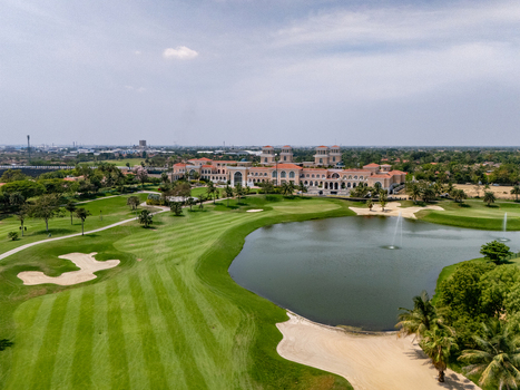 Ahmedabad Gujarat India 21 March 2026 Aerial view of Kalhaar Blues Greens Golf Club featuring lush fairways sand bunkers a large lake with fountains and the clubhouse.