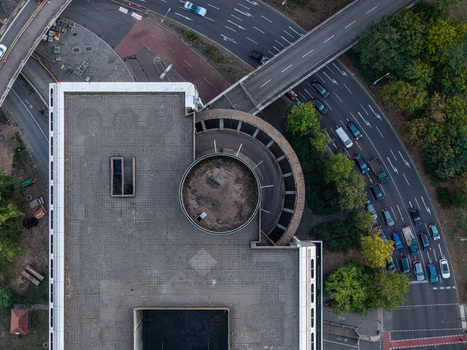 Aerial view of the brutalist architecture of the ICC Berlin featuring its distinctive circular roof structure and adjacent highway with traffic in Berlin Berlin Germany. Aerial view of the brutalist architecture of the ICC Berlin featuring its distinctive circular roof structure and adjacent highway with traffic in Berlin Berlin Germany.