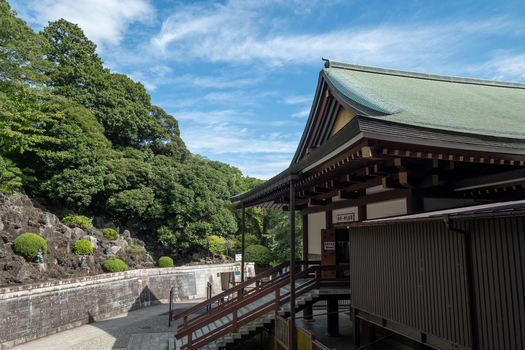 View of a traditional Japanese temple structure with a green roof nestled amongst lush greenery under a partly cloudy sky Narita Chiba Japan. View of a traditional Japanese temple structure with a green roof nestled amongst lush greenery under a partly cloudy sky Narita Chiba Japan.
