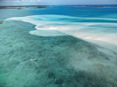 Aerial view of Man O War Cay Sandbar with turquoise water white sand and small boats anchored near people Rolletown Exuma The Bahamas. Aerial view of Man O War Cay Sandbar with turquoise water white sand and small boats anchored near people Rolletown Exuma The Bahamas.