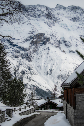 View of snow laden roofs and winding streets nestled against a majestic backdrop of towering snow capped mountains Mürren Switzerland. View of snow laden roofs and winding streets nestled against a majestic backdrop of towering snow capped mountains Mürren Switzerland.
