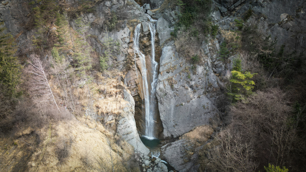Aerial view of a cascading waterfall plunging into a pool of water surrounded by rocks and vegetation Sallanches Auvergne Rhône Alpes France. Aerial view of a cascading waterfall plunging into a pool of water surrounded by rocks and vegetation Sallanches Auvergne Rhône Alpes France.