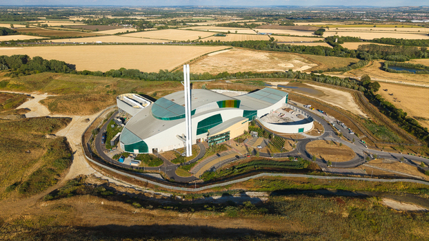 Aerial view of the Energy Recovery Facility a modern biomass to electricity plant with a tall chimney surrounded by rural agricultural fields in Bicester England United Kingdom.