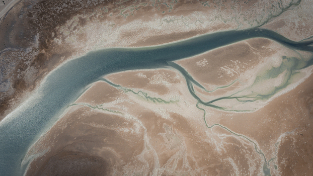 Aerial view of abstract patterns of blue water and brown sands at the coastline in Useless Loop Western Australia Australia. Aerial view of abstract patterns of blue water and brown sands at the coastline in Useless Loop Western Australia Australia.