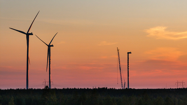Aerial view of Metsalamminkangas Tuulipuisto wind farm with wind turbines and a construction crane against a sunset sky in Siikalatva Pohjois Pohjanmaa Finland. Aerial view of Metsalamminkangas Tuulipuisto wind farm with wind turbines and a construction crane against a sunset sky in Siikalatva Pohjois Pohjanmaa Finland.