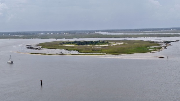 Aerial view of an island with a sandy beach surrounded by calm waters under a cloudy sky Fernandina Beach Florida United States. Aerial view of an island with a sandy beach surrounded by calm waters under a cloudy sky Fernandina Beach Florida United States.