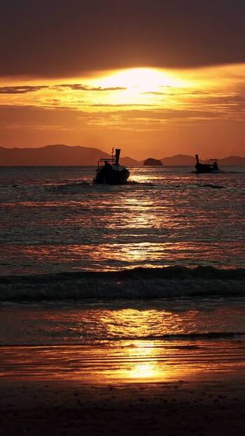 View of a boat on the water at sunset Thailand.