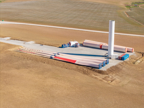 Aerial view of wind turbine components including blades and tower base at a construction site in a rural landscape Swellendam Western Cape South Africa. Aerial view of wind turbine components including blades and tower base at a construction site in a rural landscape Swellendam Western Cape South Africa.