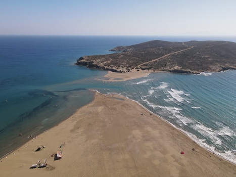 Aerial view of the Prasonisi sandbar connecting the mainland to a small island with turquoise waters and waves on the shore in Rhodos Greece.