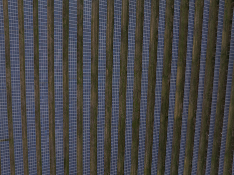 Aerial view of rows of solar panels installed in a field with green grass strips in Bulgaria. Aerial view of rows of solar panels installed in a field with green grass strips in Bulgaria.
