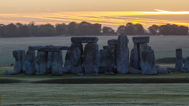 Aerial view of Stonehenge at sunrise with ancient standing stones set in the grassy landscape of Salisbury England United Kingdom. Aerial view of Stonehenge at sunrise with ancient standing stones set in the grassy landscape of Salisbury England United Kingdom.