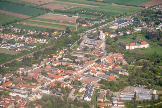 Aerial view of the village center featuring the parish church and Schloss Trautmannsdorf surrounded by green fields in Trautmannsdorf an der Leitha Niederosterreich Austria. Aerial view of the village center featuring the parish church and Schloss Trautmannsdorf surrounded by green fields in Trautmannsdorf an der Leitha Niederosterreich Austria.