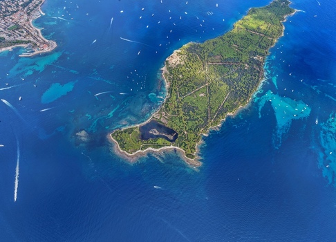 Aerial view of Ile Sainte Marguerite surrounded by turquoise waters lush green forests and numerous boats near the coast of Cannes Provence Alpes Cote d Azur France. Aerial view of Ile Sainte Marguerite surrounded by turquoise waters lush green forests and numerous boats near the coast of Cannes Provence Alpes Cote d Azur France.