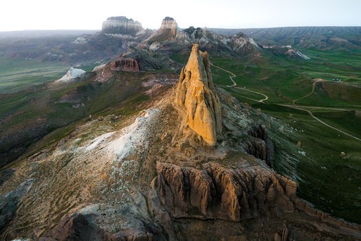 Aerial view of Airakty mountains featuring dramatic limestone rock formations rugged desert terrain and winding dirt tracks in the vast landscape of Shetpe Mangystau Region Kazakhstan.