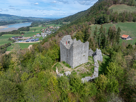Aerial view of the ruins of Burg Montsalvens surrounded by lush green forests and rolling hills in Broc Fribourg Switzerland. Aerial view of the ruins of Burg Montsalvens surrounded by lush green forests and rolling hills in Broc Fribourg Switzerland.