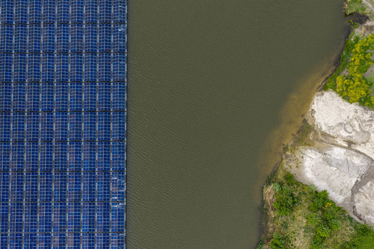 Aerial view of floating solar panels on a lake next to a sandy shoreline with green bushes in Beilen Drenthe Netherlands. Aerial view of floating solar panels on a lake next to a sandy shoreline with green bushes in Beilen Drenthe Netherlands.