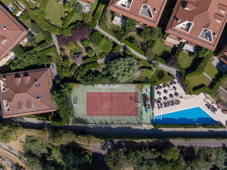 Aerial view of a tennis court and swimming pool surrounded by residential houses with red tiled roofs and lush green gardens in Istanbul Istanbul Turkiye. Aerial view of a tennis court and swimming pool surrounded by residential houses with red tiled roofs and lush green gardens in Istanbul Istanbul Turkiye.