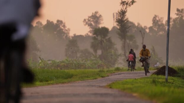 View of people riding bicycles on a rural road in Bogura Bangladesh.