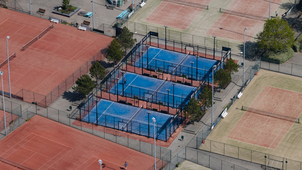 Aerial view of Tennis Padel Club Heiloo featuring blue padel courts and red clay tennis courts with players in Heiloo Noord Holland Netherlands.