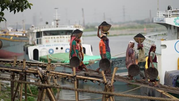View of workers carrying coal at Aminbazar port Bangladesh. View of workers carrying coal at Aminbazar port Bangladesh.