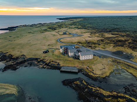 Aerial view of the historic Hotel Budir and the iconic black church set against a dramatic volcanic landscape and the Atlantic Ocean in Budir Snaefellsbaer Iceland. Aerial view of the historic Hotel Budir and the iconic black church set against a dramatic volcanic landscape and the Atlantic Ocean in Budir Snaefellsbaer Iceland.