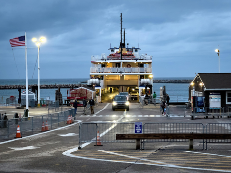 Edgartown United States 14 May 2026 View of a car disembarking from a large ferry at the Martha s Vineyard terminal under a twilight sky with the American flag waving.