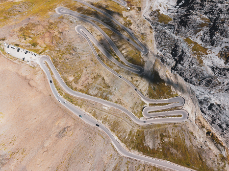 Aerial view of the winding Stelvio Pass road with its iconic hairpin turns cutting through the rugged alpine landscape in Stilfs Trentino Alto Adige Italy.