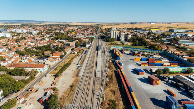 Indjija Serbia 24 August 2026 Aerial view of the railway station and industrial area with shipping containers surrounded by the town rooftops and fields under a clear blue sky.