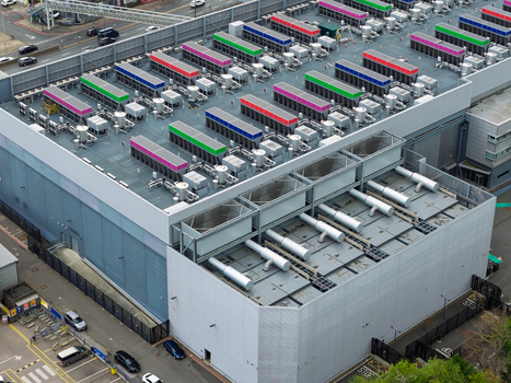 Aerial view of a modern data center featuring rows of colorful rooftop cooling units and industrial infrastructure in the United Kingdom.