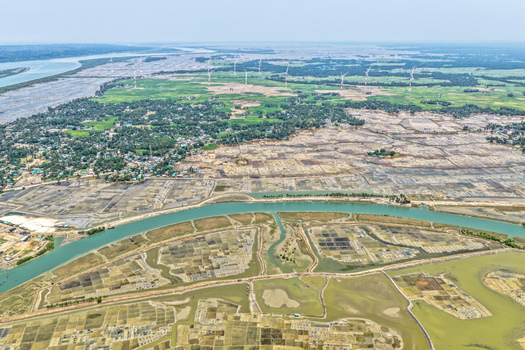 Aerial view of wind turbines standing tall amidst a patchwork of agricultural lands and waterways Cox s Bazar Chittagong Division Bangladesh. Aerial view of wind turbines standing tall amidst a patchwork of agricultural lands and waterways Cox s Bazar Chittagong Division Bangladesh.
